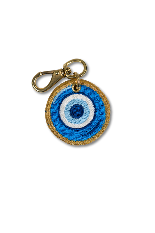 Wild Thread Studio embroidered Blue Evil Eye charm in concentric rings of cobalt sky blue and white with gold border and solid brass hardware